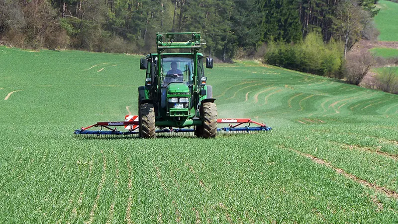 Traktor beim Düngen auf dem Feld