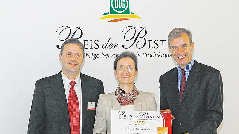 Drei Personen mit der Auszeichnung „Preis für langjährige Produktqualität“