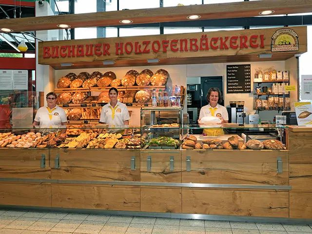 Innenansicht einer Bäckerei mit lächelnder Verkäuferin