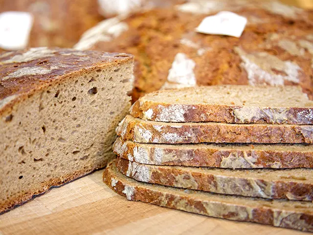 Aufgeschnittenes dunkles Brot auf einem Brett