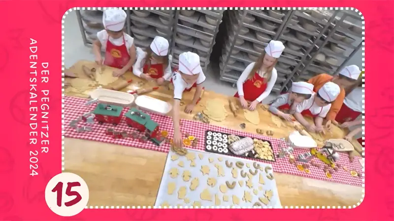 Kinder backen an großem Tisch Weihnachtsplätzchen